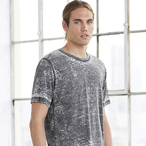Male model in grey acid-washed t-shirt standing near window, representing vintage-style 2025 streetwear trend