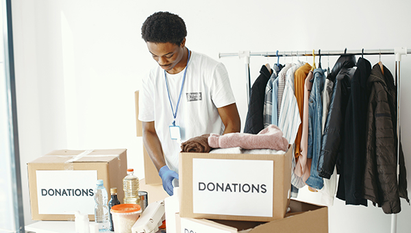 volunteer organizing clothing donations in boxes for charity and community support
