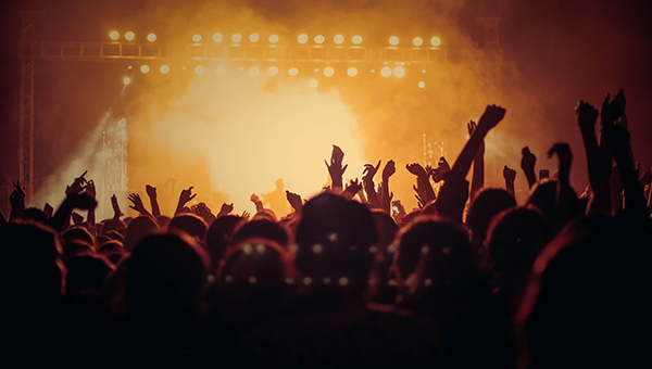 crowd cheering at live concert with stage lights and music performance