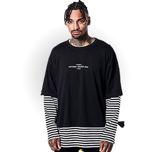 Man wearing double sleeve t-shirt with striped long sleeves under black tee, highlighting streetwear layering trend