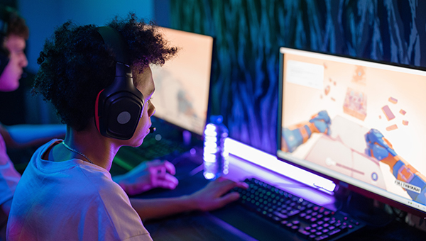 kids playing video games on computer with headphones colorful gaming setup