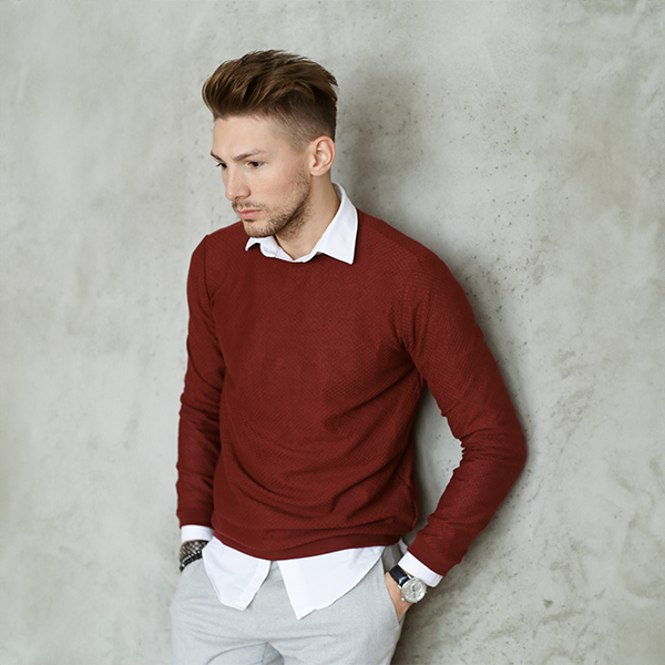 man wearing red sweater layered over white shirt casual corporate style outfit