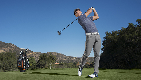 golfer wearing performance polo shirt swinging golf club on course outdoor sports apparel