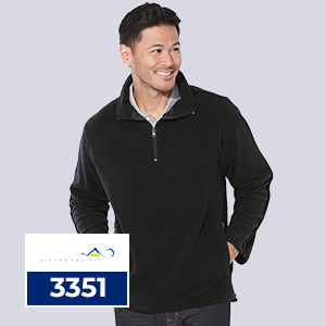 A smiling man wearing a black Sierra Pacific 3351 microfleece quarter-zip pullover with a stand collar, designed for wholesale team apparel, layering, and custom decoration.