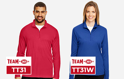A man wearing a red Team 365 TT31 and a woman wearing a blue Team 365 TT31W performance quarter-zip pullover, both designed with moisture-wicking and UV protection for wholesale team apparel and custom decoration.